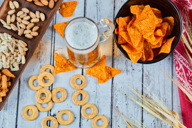 istock Assorted snacks, chips, and beer on blue table. Table for group of friends 1298452241