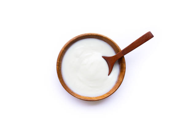 istock White yogurt in wooden bowl on white background. 1298456395