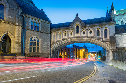 Stock photograph of the enclosed stone arch bridge that connects Christ Church Cathedral to the Synod Hall across Winetavern Street in Dublin Ireland at twilight blue hour.