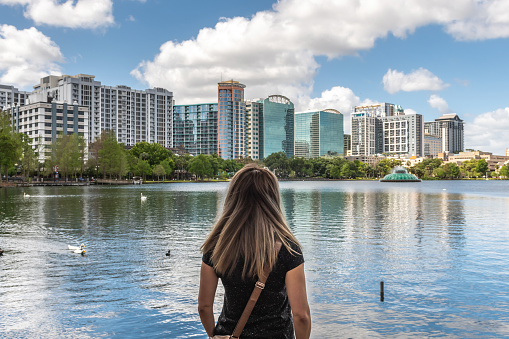 Woman looking at Lake Eola Park in Orlando, Florida, on a sunny day of springtime.