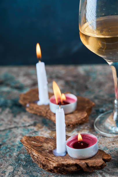 Glass of white wine and candles on marble table. High quality photo