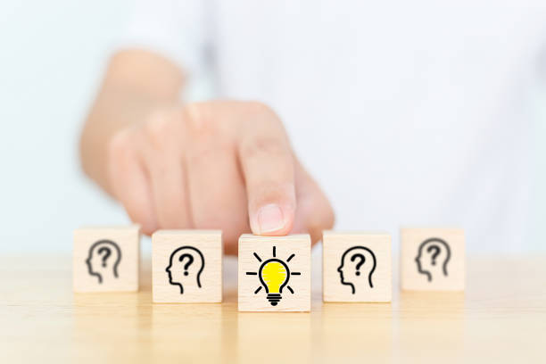 istock Concept creative idea and innovation. Hand choose wooden cube block with head human symbol and light bulb icon 1298483864