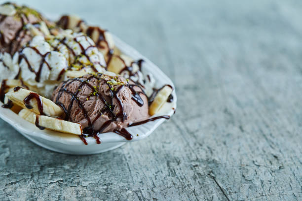 istock Ice-cream with bananas, chocolate and sprinkles on the white plate 1298486087