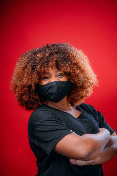 istock Young African American Woman Smiling Under a Cloth Protective Face Mask 1298494443