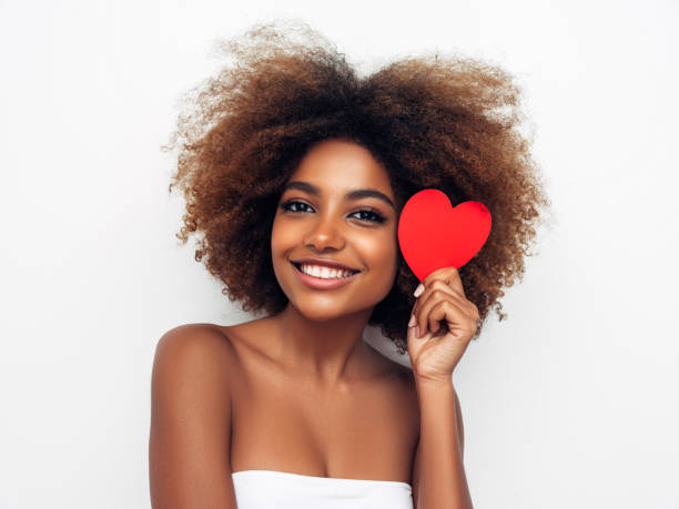 istock Beautiful afro woman holding artificial heart 1298494727