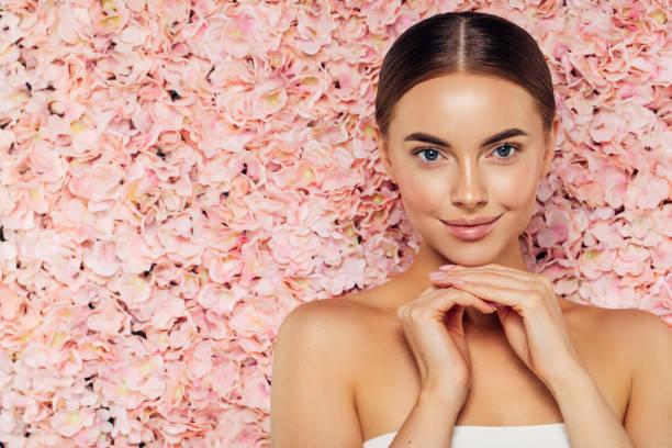 istock Beautiful girl with a wall of flowers 1298495607