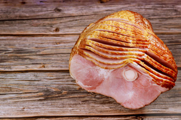 istock Spiral sliced pork ham isolated on wooden background. 1298501006