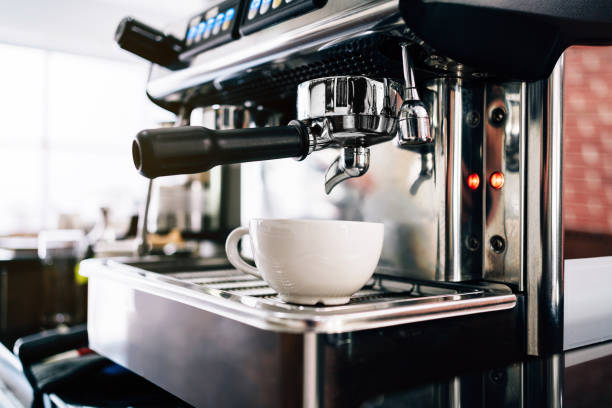 la mano de barista de primer plano inserta el filtro metálico en la cafetera, esperando a verter café negro caliente dentro de una taza. - coffee black coffee cup coffee bean fotografías e imágenes de stock