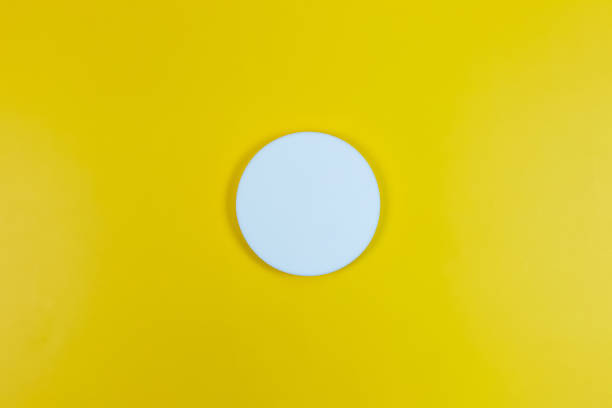 istock Blank white circle isolated on yellow background with shadow 1298510325