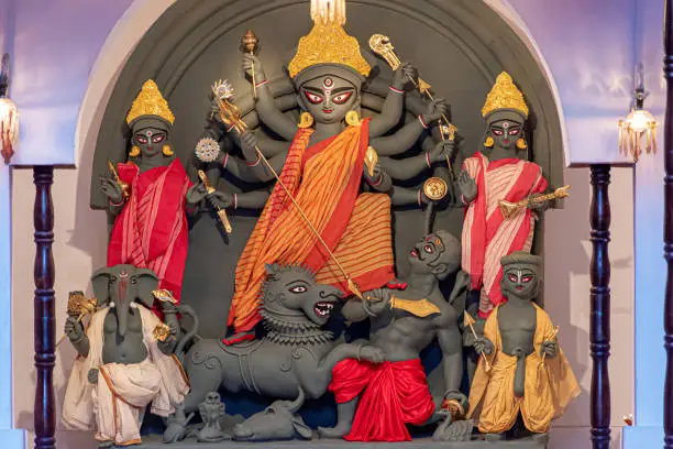 Goddess Durga idol at decorated Durga Puja pandal, shot at colored light, in Kolkata, West Bengal, India. Durga Puja is biggest religious festival of Hinduism and is now celebrated worldwide.