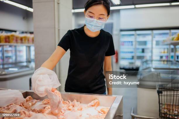 An Asian Chinese Woman With Protective Face Mask Buying Fresh Chicken Meat In Supermarket Stock Photo - Download Image Now
