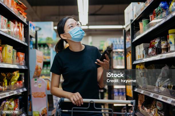 Asian Woman With Protective Face Mask Shopping For Groceries In Supermarket Stock Photo - Download Image Now