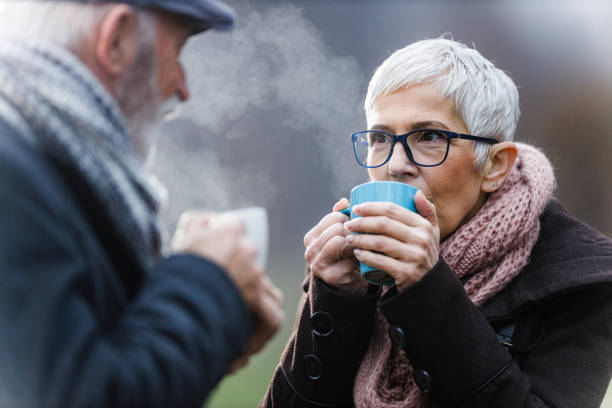 istock Senior couple drinking hot drink in nature. 1298522644