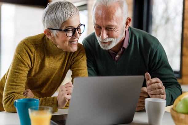 istock Happy mature couple having a video call over computer at home. 1298523293