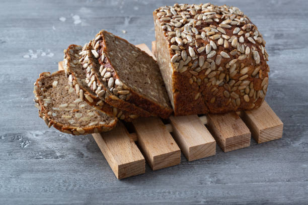 istock Sliced rye bread on cutting board. Whole grain rye bread with seeds 1298524962