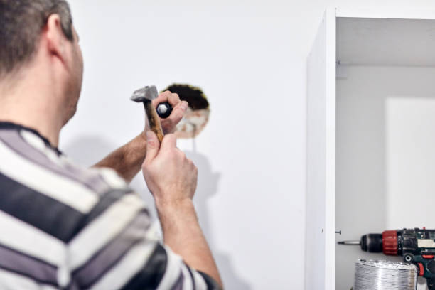 istock Handyman worker making hole for airduct ventilation in the kitchen. 1298528506