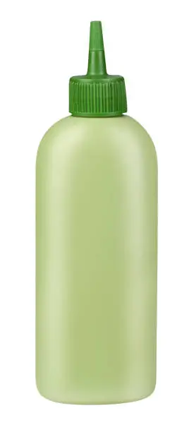 Green plastic bottle of hair dye solvent with closed pointed lid, no label