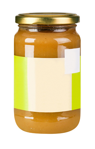 Glass jar of industrial apricot marmalade closed with metallic lid, blank label, isolated on white