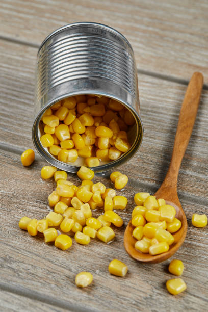istock A can of boiled sweet corn on a wooden table with a spoon 1298538569