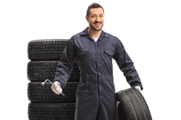 istock Auto mechanic holding a tire and a wrench 1298538754