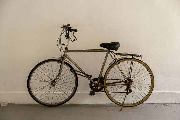 istock Rusty and dirty vintage bicycle by a white painted wall 1298543011