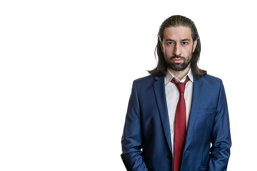 Charismatic businessman with beard and long hair in blue jacket and red tie isolated on white background. Portrait of an office worker.  Copy space.