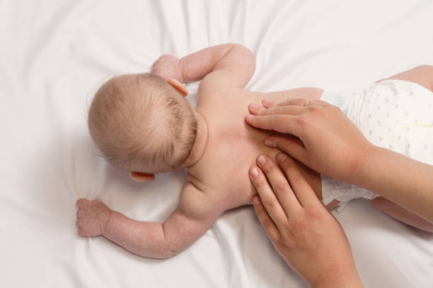 istock baby massage, close-up hands on baby back 1298547955