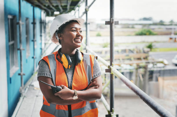 Putting in the dedication to build her dreams Shot of a young woman working at a construction site walkie talkie photos stock pictures, royalty-free photos & images