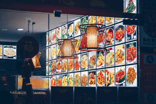 Chinese food restaurant in Chinatown, Singapore, showing pictures of the menu on the wall inside the restaurant. Seen a late evening.