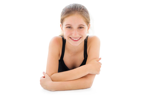 Cute teenager girl lying on a floor isolated on a white background