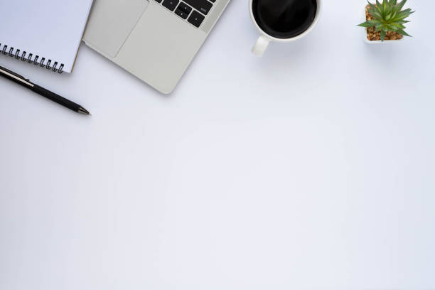 istock Top view above of White office desk table with keyboard, notebook and coffee cup with equipment other office supplies. Business and finance concept. Workplace, Flat lay with blank copy space. 1298553540