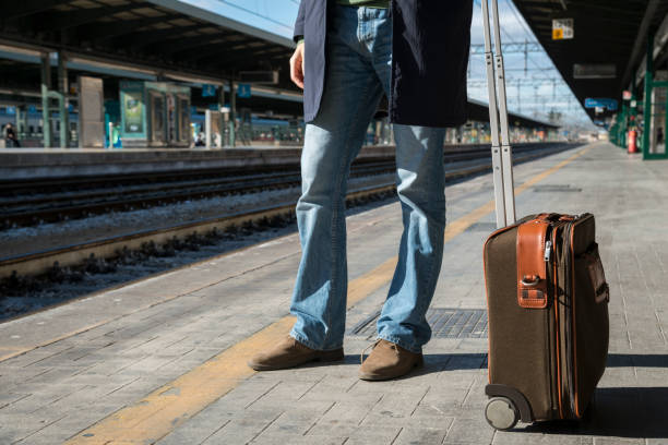 istock young man waiting for the train in a train station 1298554101
