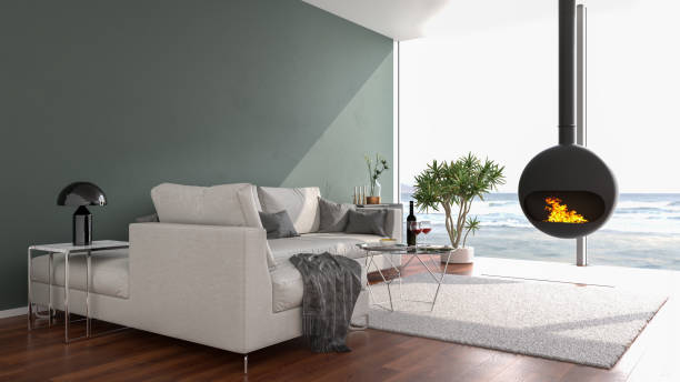 istock Modern loft style apartment with a stylish fireplace looking out to a beach through large floor-to-ceiling windows. 3d render 1298554616