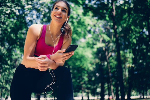 istock Happy sportswoman taking a break in nature an using phone. 1298554910