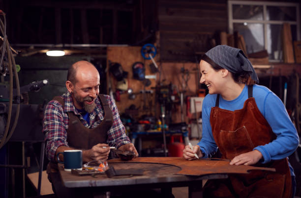 istock Male And Female Blacksmith Working On Design In Forge Together 1298556337