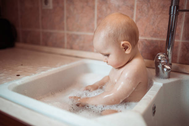 istock Baby having a bath in a kitchen sink 1298558326