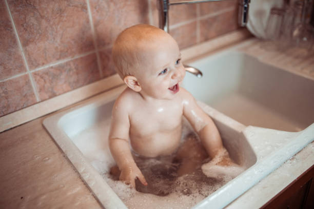 istock Cute baby having a bath in a kitchen sink 1298558397