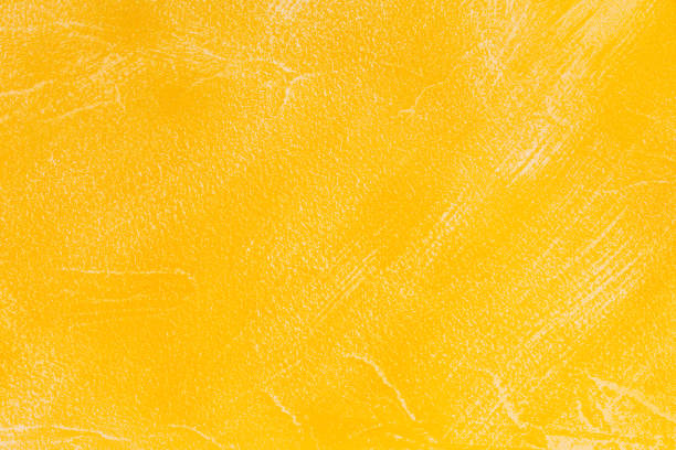 istock Abstract yellow empty bright colorful decorative plaster background with rough textured shabby surface 1298558404