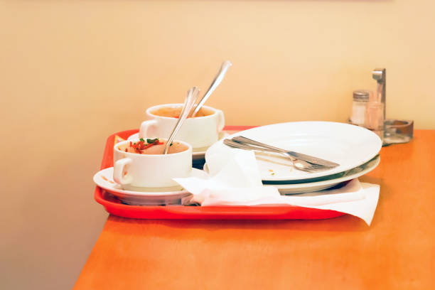 食べた後、トレイに食器を空にします。昼食を食べた後の食べ物に食器を使った。テーブルの上のキッチントレイに空のプレート、スープのためのカップ、汚れたナプキン - plate crumb dirty fork ストックフォトと画像