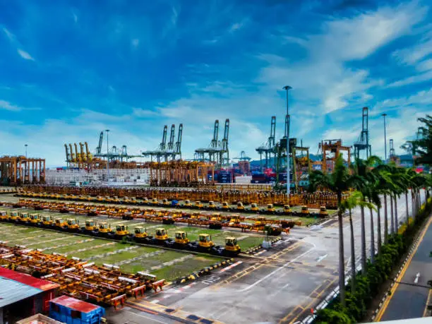 Singapore, Singapore - August 05, 2018:  Amazing view of a container terminal at the Port of Singapore. Ship-to-shore gantry cranes at shipping yard.