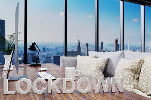 istock corona crisis lockdown; cozy couch in front of modern workspace with computer and skyline view; work from home concept; codiv 19; 3D Illustration 1298563700