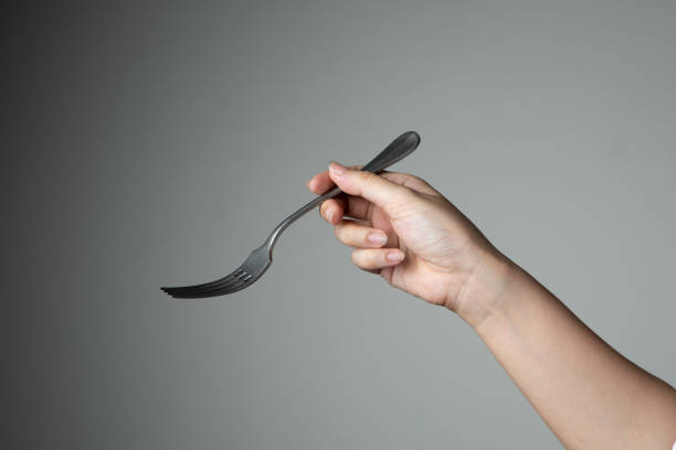fork with hand on grey background utensil kitchen for cooking