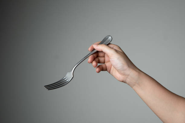 istock fork with hand on grey background utensil kitchen for cooking 1298565383
