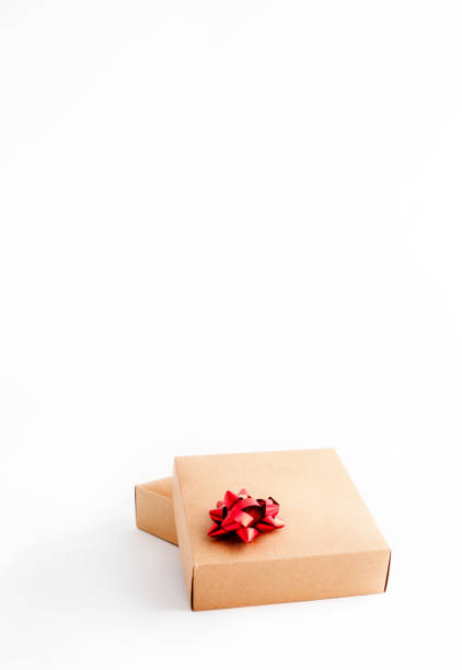 istock Cardboard gift box with red ribbon on white background 1298565424