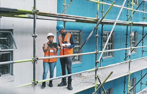 Shot of a young man and woman using a digital tablet while working at a construction site