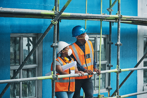 Shot of a young man and woman working at a construction site
