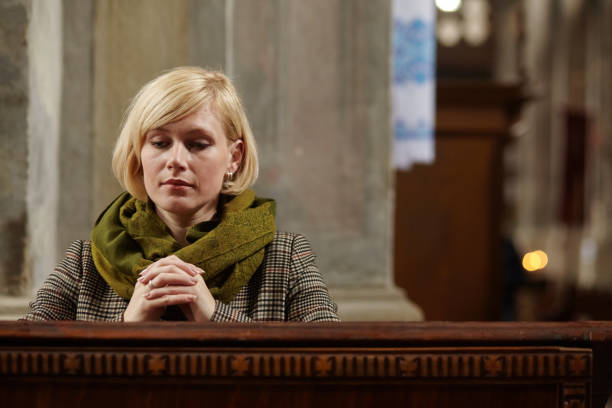 istock Young woman praying in a church 1298565977