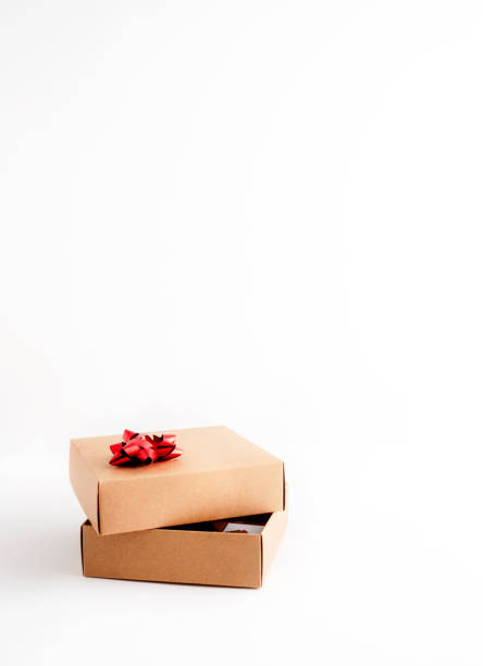 istock Cardboard gift box with red ribbon on white background 1298566214