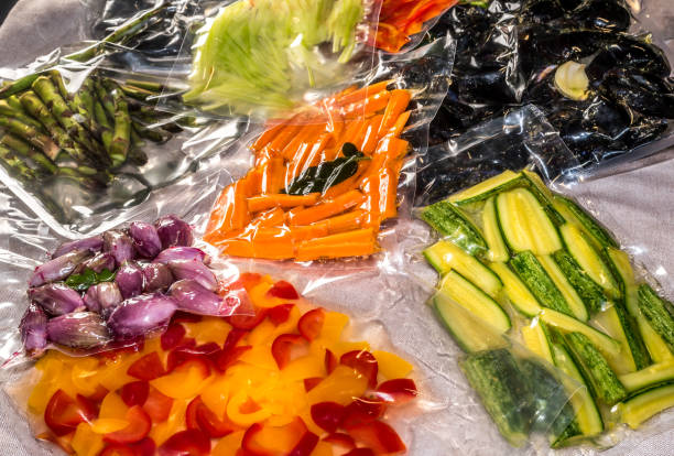 vacuum sealed bags food vacuum sealed bags for sous vide cooking with peppers and courgettes and shallots, fresh carrots and asparagus and mussels vacuum packed stock pictures, royalty-free photos & images