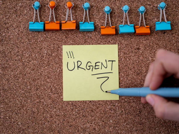 istock Adhesive note with urgent text pinned on a bulletin board 1298568330